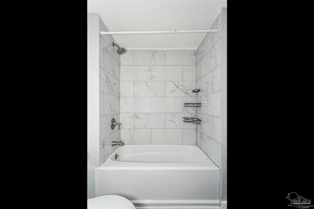 bathroom with tiled shower / bath combo and toilet