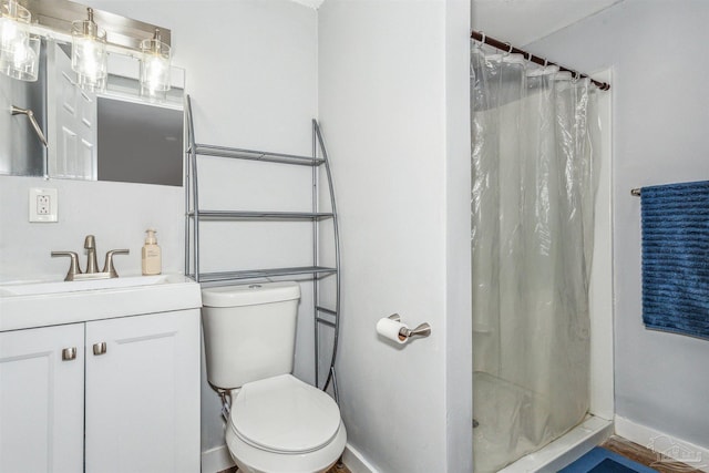 bathroom featuring vanity, curtained shower, and toilet