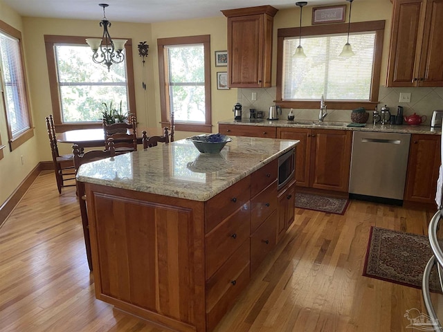 kitchen featuring hanging light fixtures, a kitchen island, sink, and appliances with stainless steel finishes