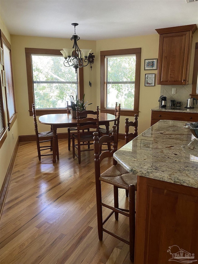 dining room with light wood-type flooring and a chandelier