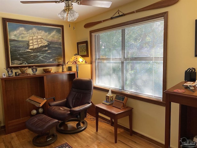 living area featuring hardwood / wood-style flooring, ceiling fan, and a healthy amount of sunlight