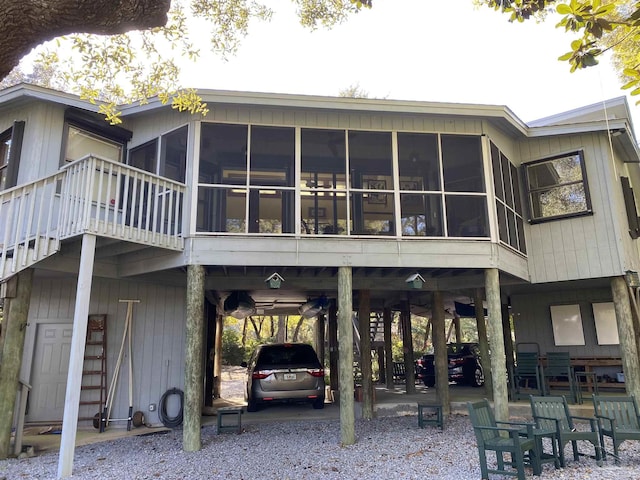 back of property featuring a carport and a sunroom