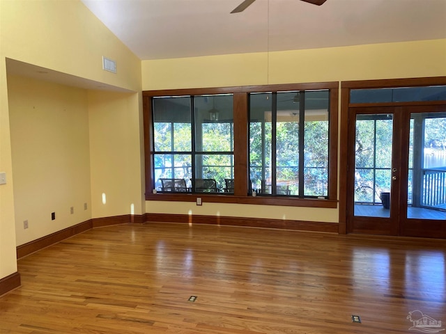 unfurnished room with french doors, vaulted ceiling, ceiling fan, and hardwood / wood-style floors