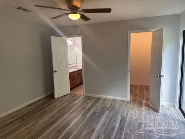 2301 W Michigan Ave Unit 25, Pensacola, FL 32526 - unfurnished bedroom featuring wood finished floors, a ceiling fan, and ensuite bath