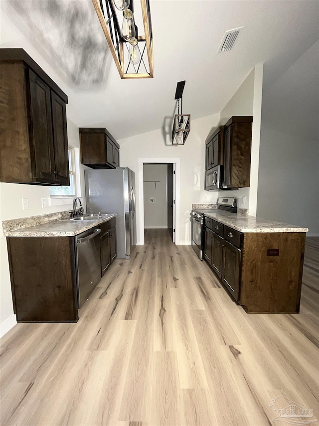 kitchen with dark brown cabinetry, sink, stainless steel appliances, and light hardwood / wood-style flooring