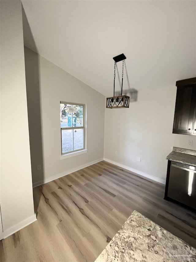 unfurnished dining area with hardwood / wood-style flooring and lofted ceiling