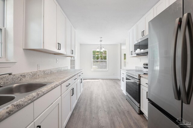 kitchen with hardwood / wood-style floors, stainless steel appliances, and white cabinets