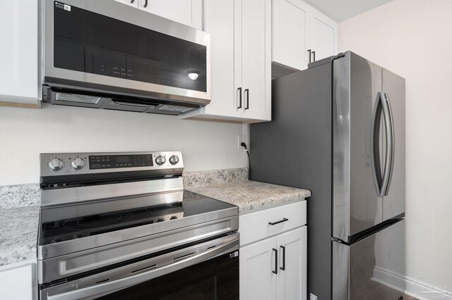 kitchen with stainless steel appliances and white cabinetry