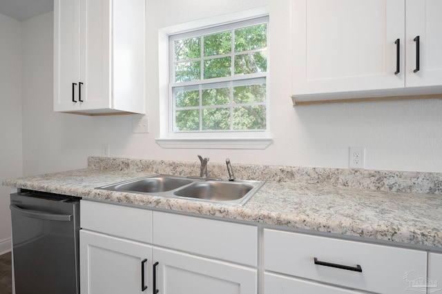 kitchen featuring dishwasher, light countertops, white cabinetry, and a sink