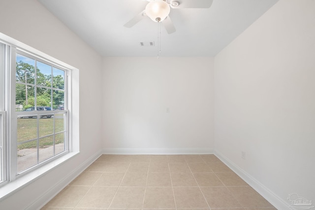 empty room with a ceiling fan, light tile patterned floors, baseboards, and visible vents