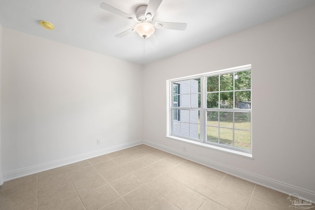 unfurnished room with baseboards, ceiling fan, and light tile patterned flooring