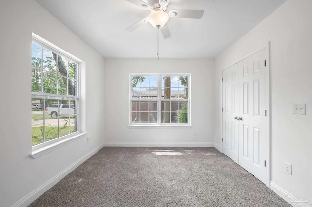 spare room featuring plenty of natural light, ceiling fan, and carpet flooring