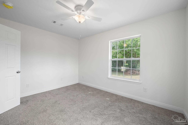 spare room with visible vents, carpet flooring, a ceiling fan, and baseboards