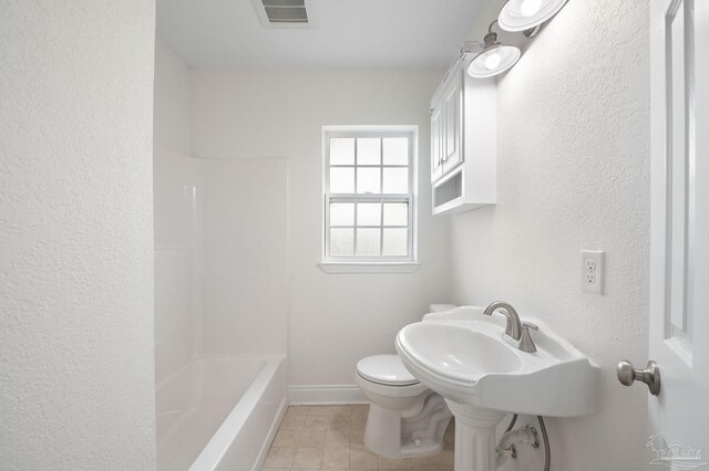 bathroom featuring toilet, shower / bathtub combination, and tile patterned flooring