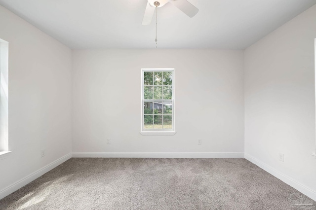 carpeted empty room featuring baseboards and ceiling fan