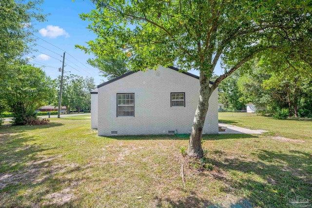 view of property exterior featuring a lawn, brick siding, and crawl space