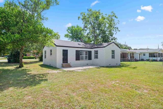rear view of house featuring a lawn, entry steps, crawl space, brick siding, and a patio area