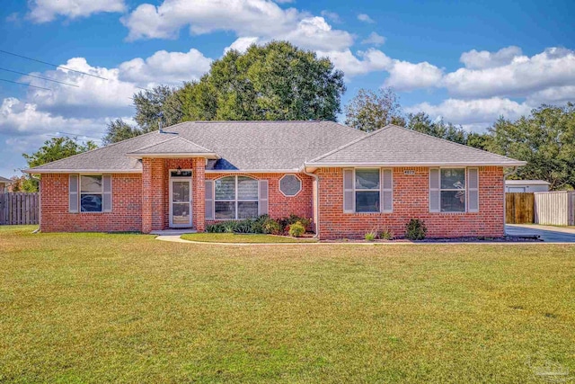 single story home with brick siding, roof with shingles, fence, and a front yard