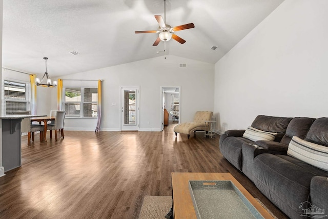 living room with ceiling fan with notable chandelier, dark wood-type flooring, and lofted ceiling