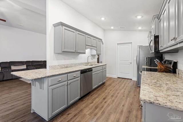 kitchen with gray cabinets, wood-type flooring, sink, and appliances with stainless steel finishes