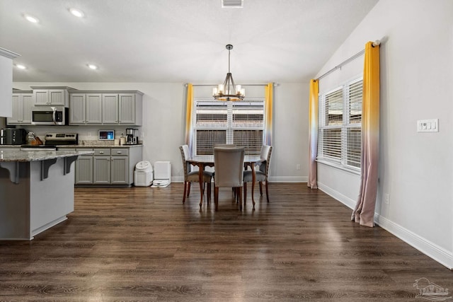 dining room with dark hardwood / wood-style flooring, lofted ceiling, and an inviting chandelier