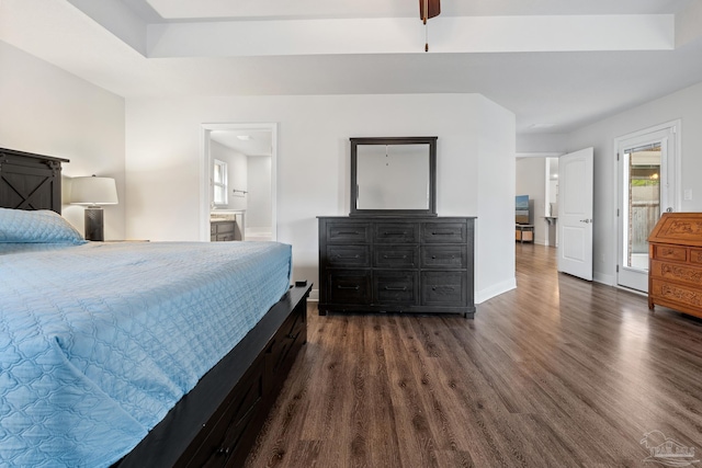 bedroom with ensuite bathroom and dark wood-type flooring