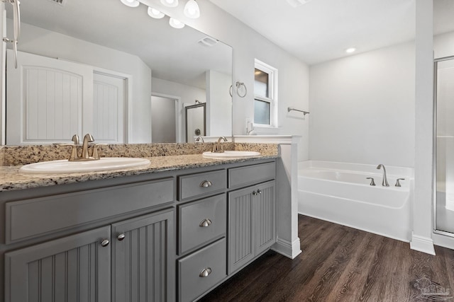 bathroom with plus walk in shower, wood-type flooring, and vanity