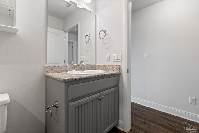 bathroom featuring hardwood / wood-style floors, vanity, and toilet