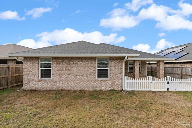 rear view of property with a lawn