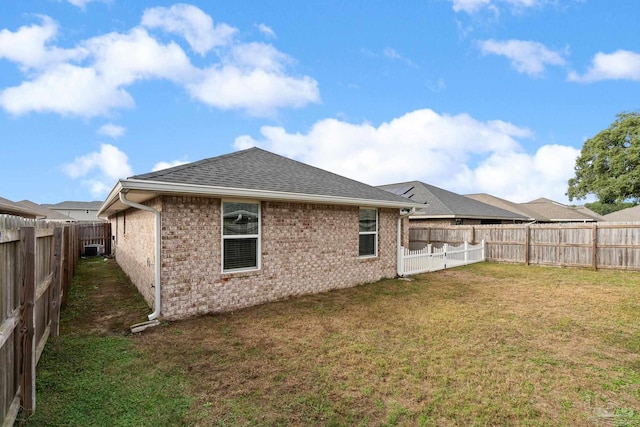 rear view of house with a yard and central AC unit