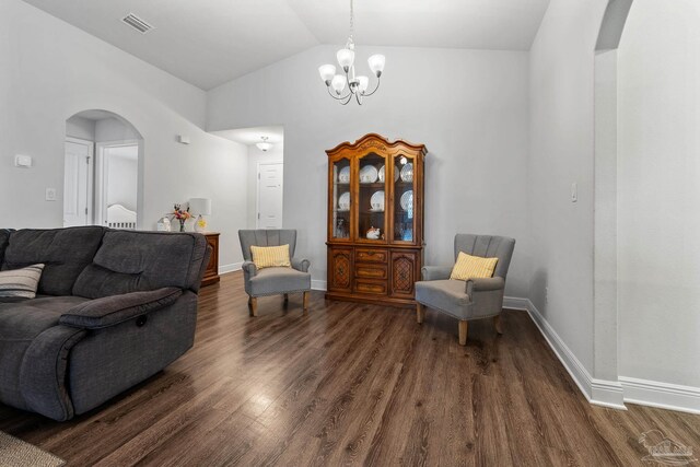 living area featuring a chandelier, lofted ceiling, and dark wood-type flooring