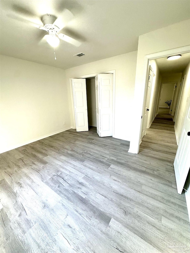 unfurnished bedroom featuring a closet, light hardwood / wood-style floors, and ceiling fan