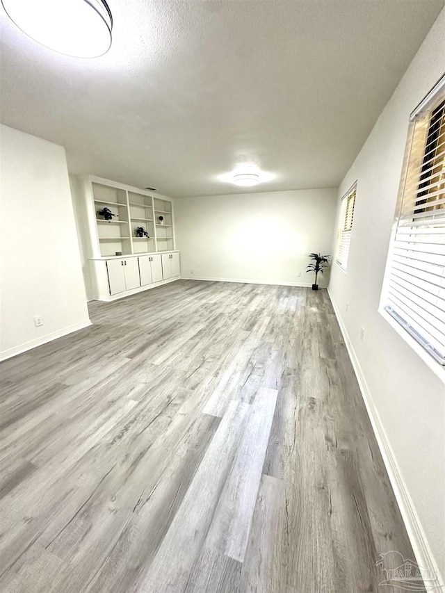 basement with hardwood / wood-style floors and a textured ceiling