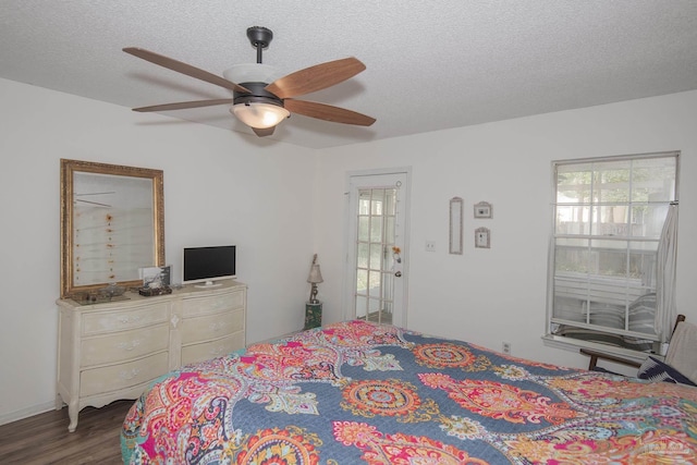 bedroom featuring ceiling fan, hardwood / wood-style floors, multiple windows, and a textured ceiling