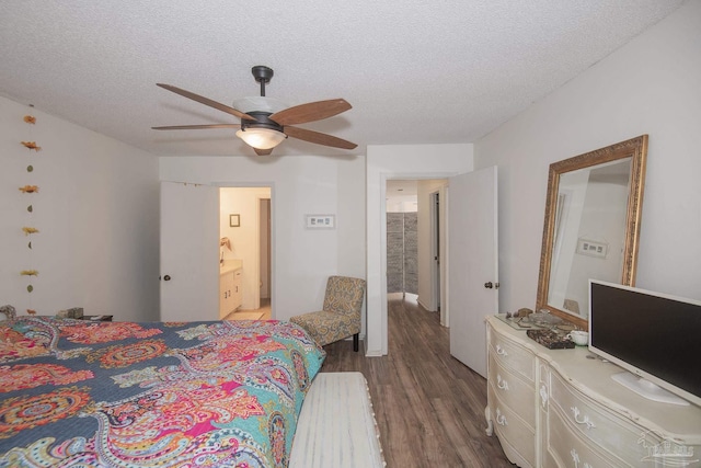 bedroom with ceiling fan, connected bathroom, a textured ceiling, and light hardwood / wood-style flooring