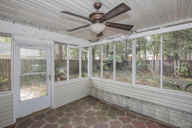 unfurnished sunroom featuring ceiling fan