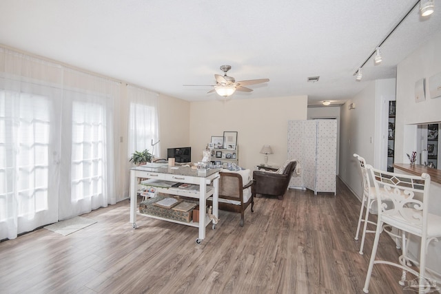 dining space featuring ceiling fan, wood-type flooring, and track lighting