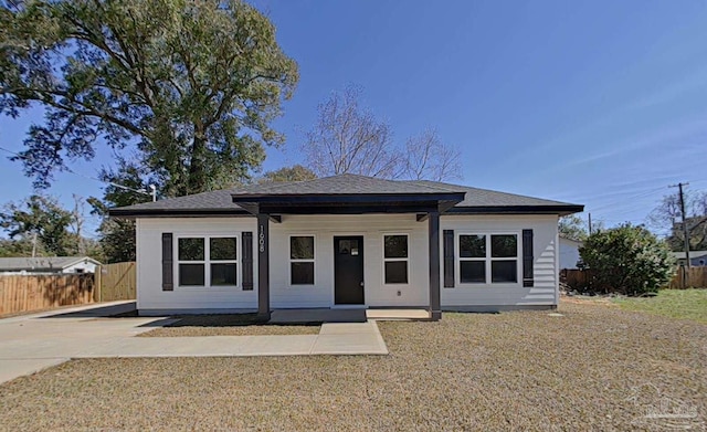 bungalow-style house with a shingled roof and fence