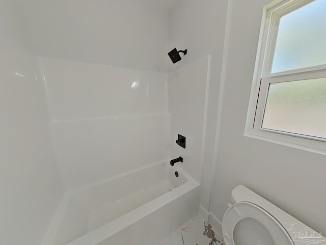 full bathroom with toilet, marble finish floor, bathing tub / shower combination, and a wealth of natural light