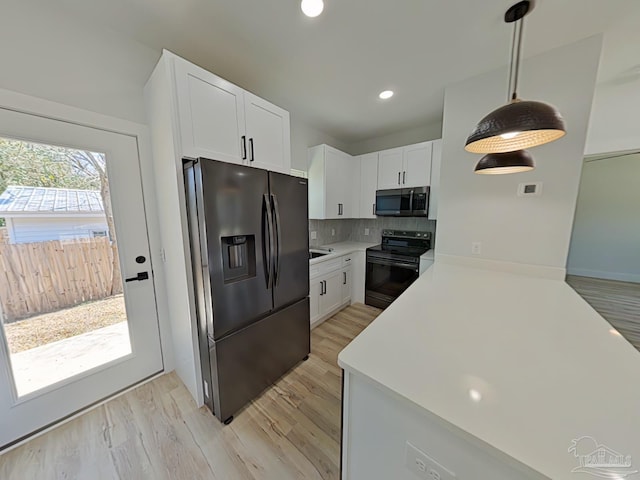 kitchen featuring black range with electric cooktop, light countertops, fridge with ice dispenser, decorative backsplash, and stainless steel microwave