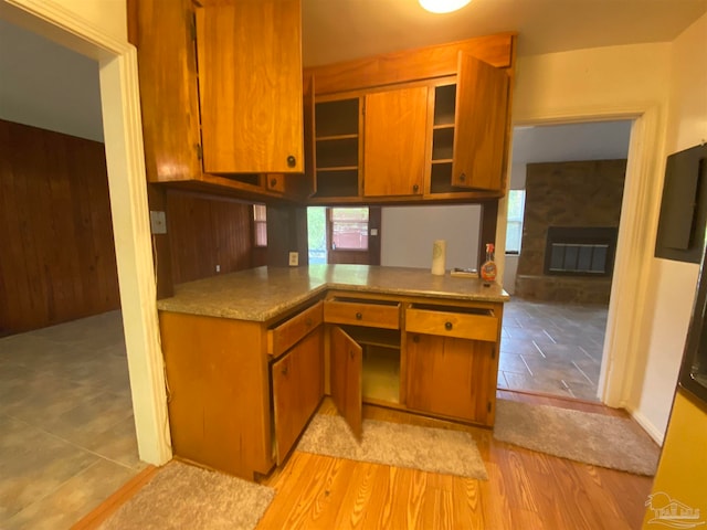 kitchen featuring light wood-type flooring, a fireplace, and built in desk