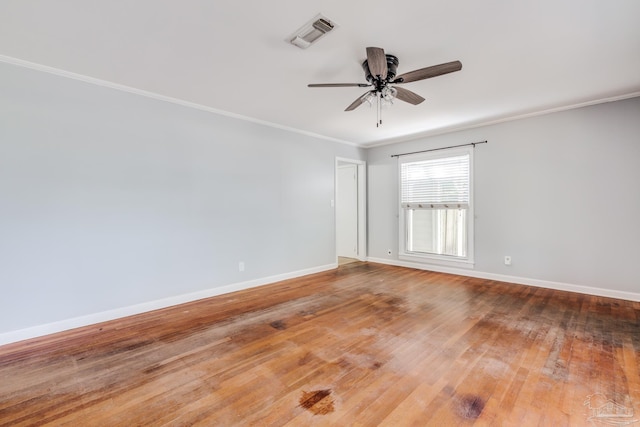 unfurnished room featuring crown molding, baseboards, visible vents, and wood-type flooring