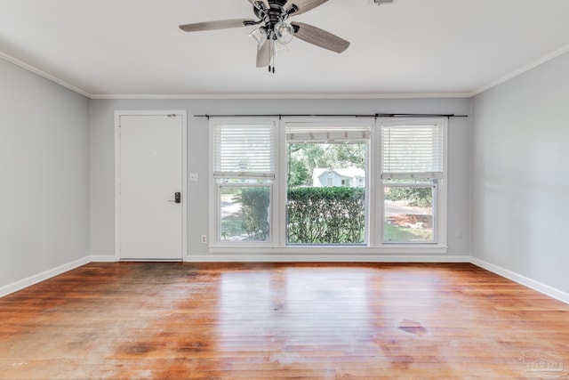 unfurnished room with wood finished floors, baseboards, and ornamental molding