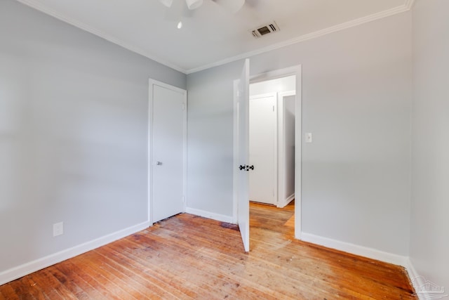 unfurnished bedroom with visible vents, baseboards, ornamental molding, and light wood finished floors