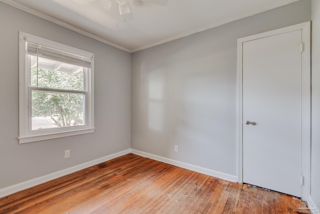 unfurnished room featuring hardwood / wood-style floors, crown molding, a ceiling fan, and baseboards