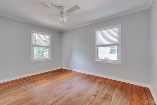 spare room featuring baseboards, light wood-type flooring, and ornamental molding