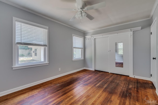 unfurnished bedroom with a closet, baseboards, hardwood / wood-style floors, and crown molding