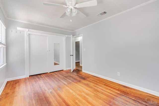 unfurnished bedroom with baseboards, visible vents, light wood-style flooring, ceiling fan, and ornamental molding