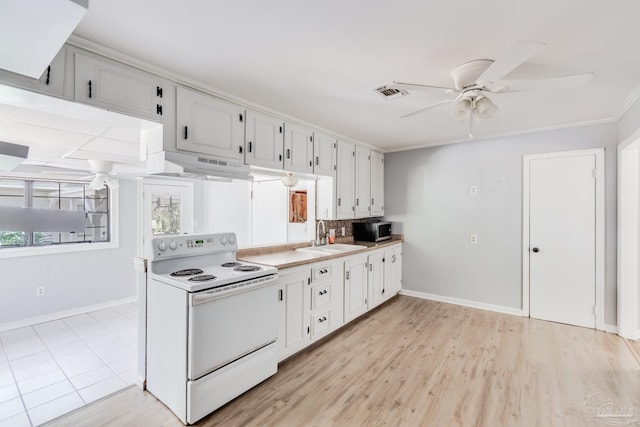 kitchen with visible vents, white range with electric cooktop, a sink, under cabinet range hood, and stainless steel microwave