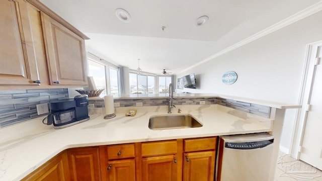 kitchen with a sink, dishwasher, tasteful backsplash, brown cabinetry, and crown molding